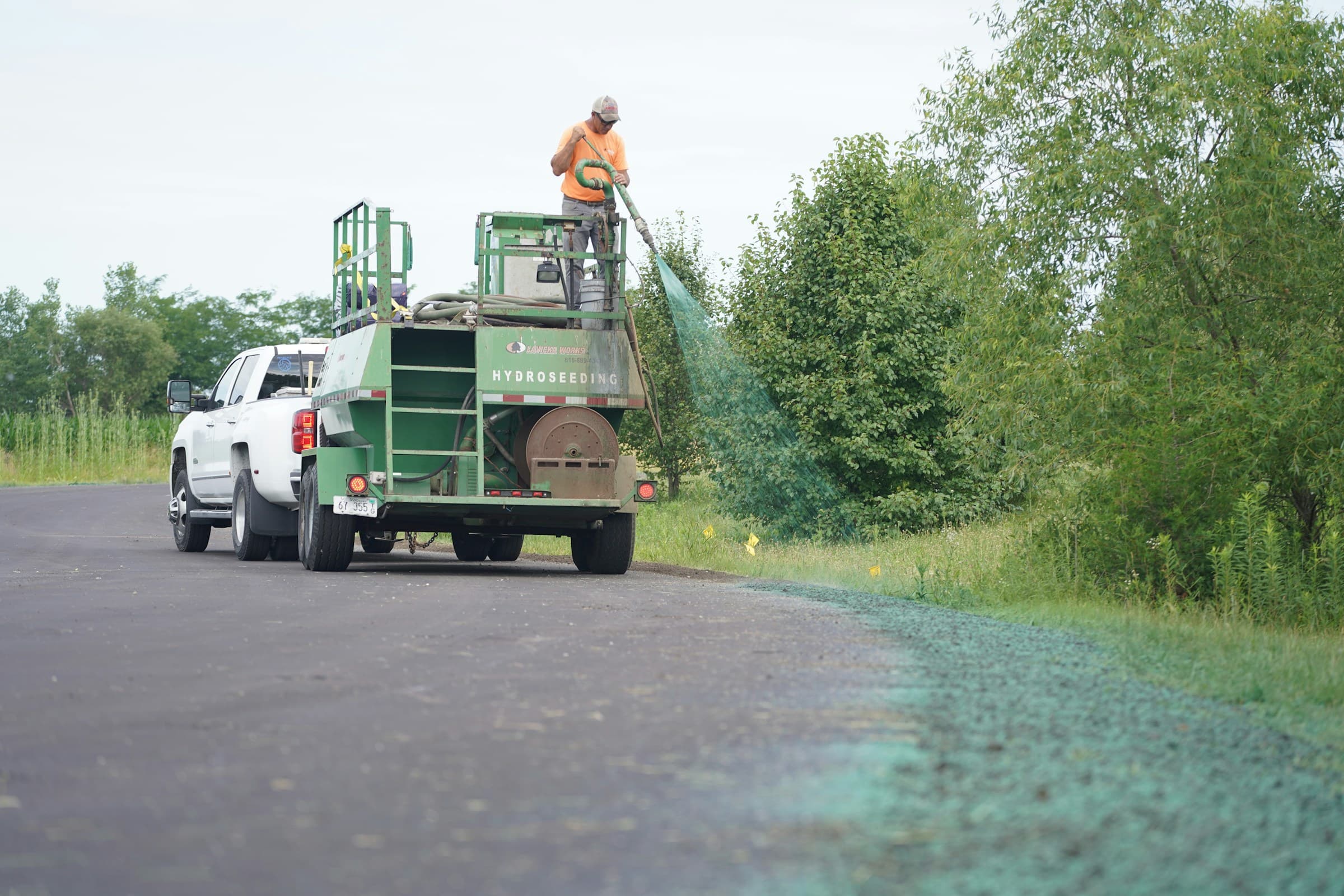 Professionnel de l'hydroseeding évaluant un terrain avant la préparation d'un devis