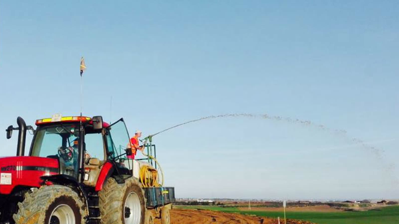 Projection d'un mélange d'hydroseeding depuis une machine agricole sur un terrain préparé